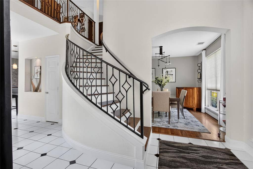 4243 Millview Lane, Dallas, TX 75287 Step inside to a breathtaking two-story foyer that immediately sets the tone for the home. Soaring ceilings and an abundance of natural light create a grand, open feel, while the elegant staircase serves as a stunning architectural focal point.