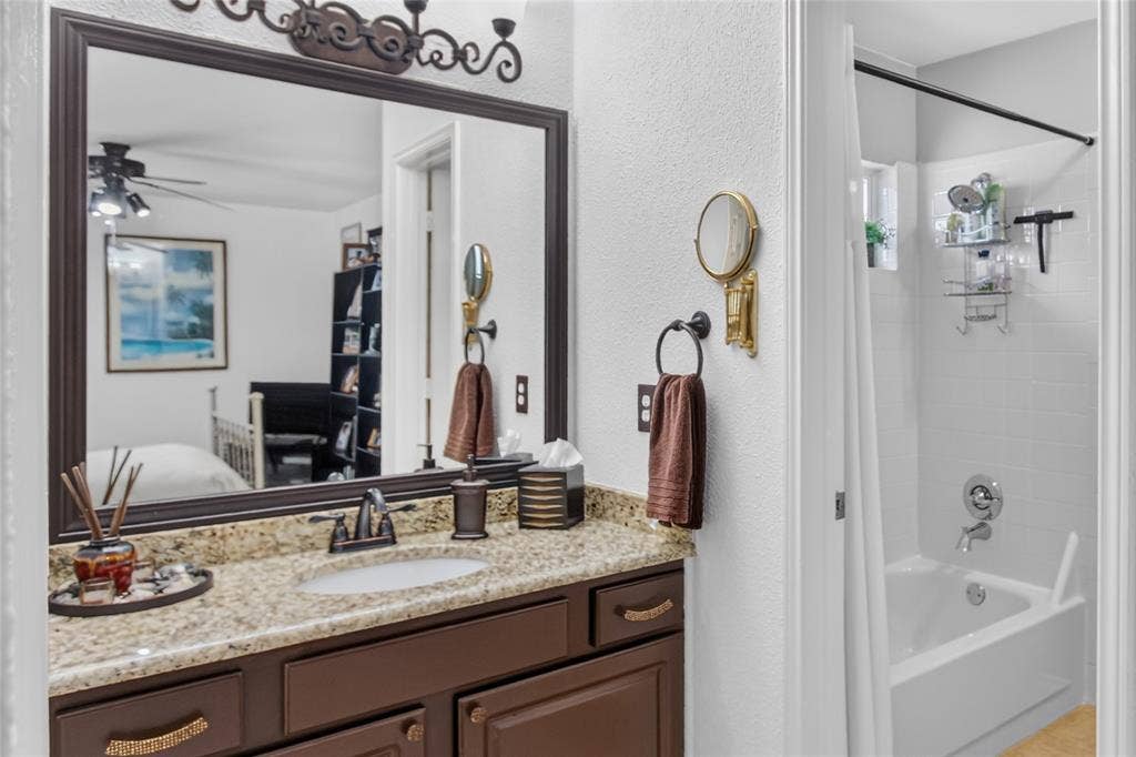 4243 Millview Lane, Dallas, TX 75287 View of one of the two sink areas supporting the Jack N Jill bath up. Granite counter top, full size mirror, shower-tub combination. Identical vanity on opposite end of Jack N Jill bathroom.