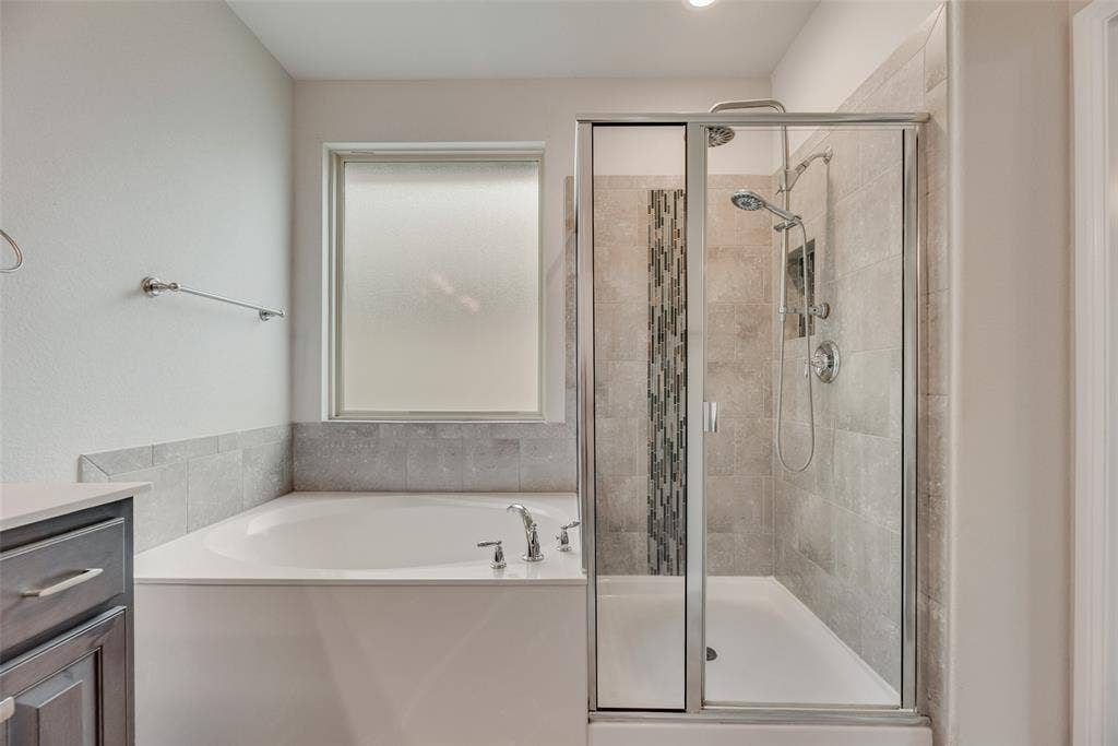 Full bath with a garden tub, a stall shower, and vanity