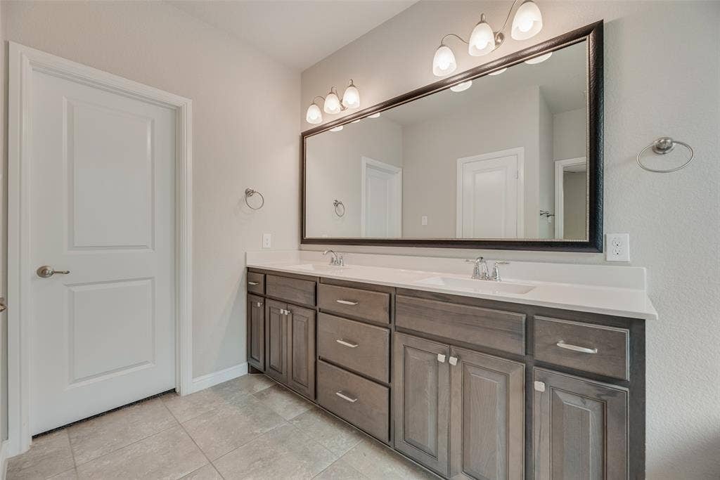 Full bath featuring double vanity and tile patterned flooring