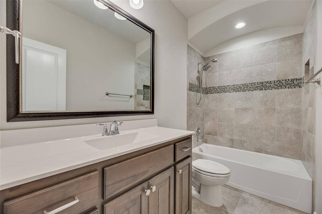 Full bath featuring vanity, shower / tub combination, and tile patterned floors
