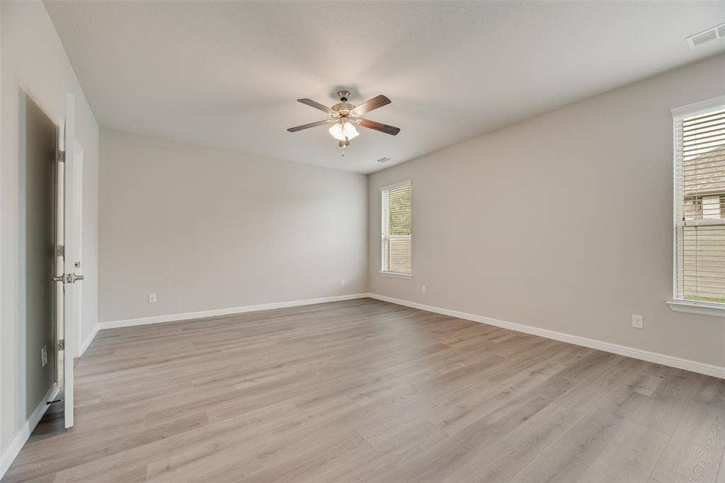 Empty room featuring ceiling fan and light wood-style flooring