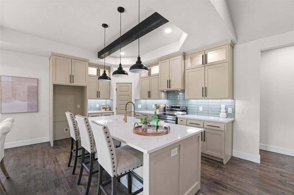 609 Luzon Street, Tool, TX 75143 Contemporary kitchen featuring an expansive island with a quartz countertop, under-cabinet lighting, a subway tile backsplash, recessed lighting, and wood-finish flooring