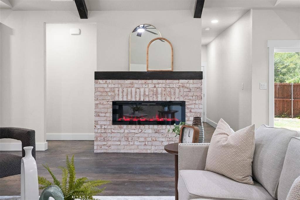 609 Luzon Street, Tool, TX 75143 Living area featuring a white-washed brick fireplace with a dark wood mantle, dark wood-finish flooring, and white baseboards