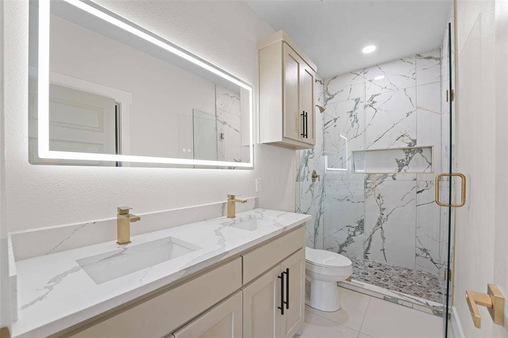 609 Luzon Street, Tool, TX 75143 Contemporary bathroom featuring a double vanity with integrated rectangular sinks, a quartz-finish countertop, and gold-tone fixtures