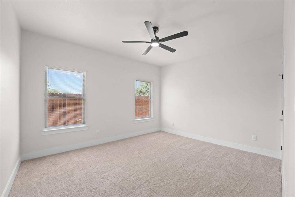 609 Luzon Street, Tool, TX 75143 Spacious room featuring neutral carpeting, light-toned walls, and a modern ceiling fan with integrated lighting