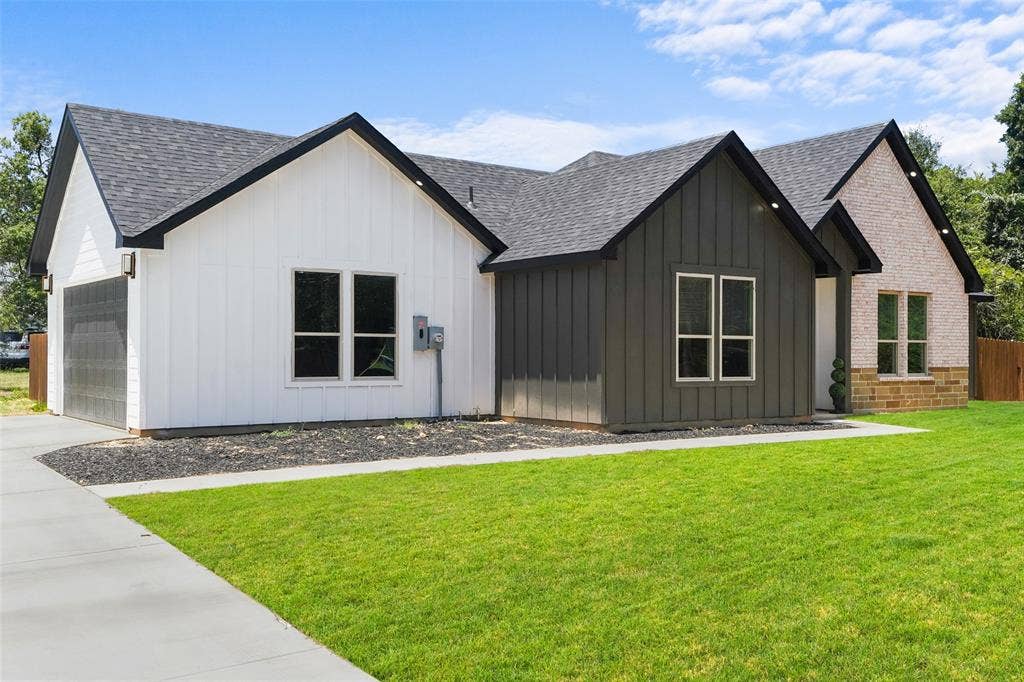 609 Luzon Street, Tool, TX 75143 Contemporary exterior featuring a combination of white vertical siding, dark vertical siding, and light-toned brick