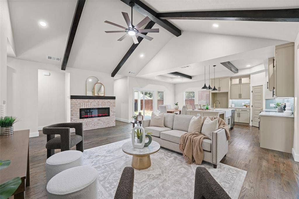 609 Luzon Street, Tool, TX 75143 Vaulted ceilings with exposed beams, wood-finish flooring, and a contemporary fireplace with brick surround