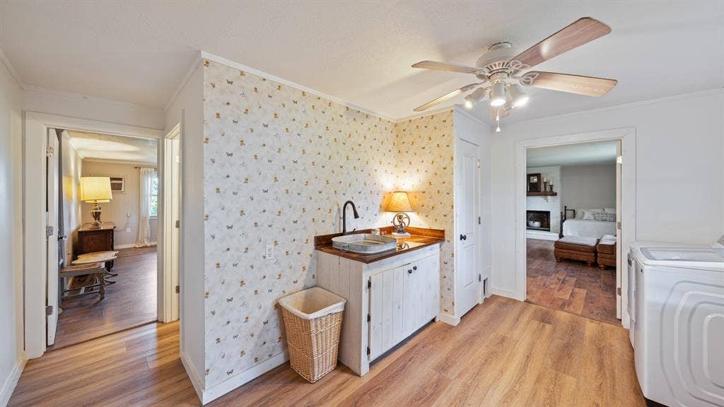 1053 Vz County Road 4206, Athens, TX 75752 Utility area featuring wood-finish flooring, a ceiling fan with integrated lighting, and a built-in utility sink with a dark-finish faucet