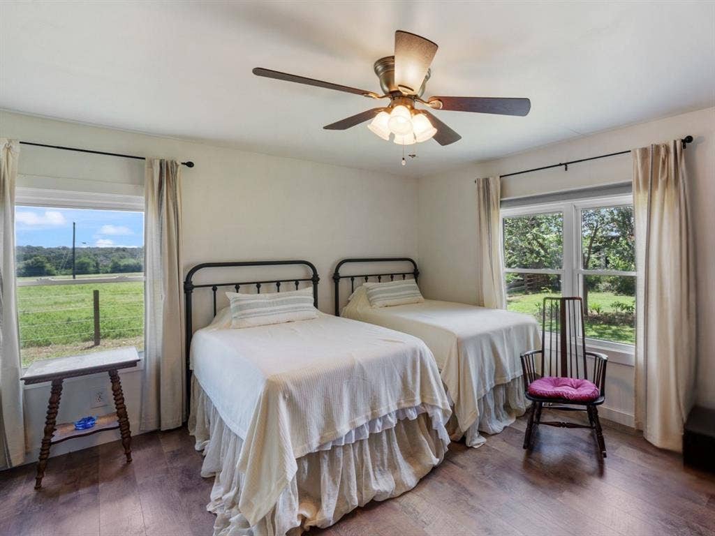 1053 Vz County Road 4206, Athens, TX 75752 Spacious room featuring wood-finish flooring, two large windows, a ceiling fan with light fixture, and white walls