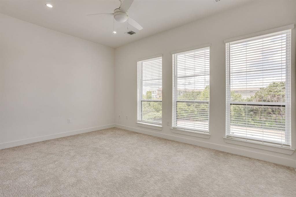 123 Thornton Street, Arlington, TX 76013 Carpeted room featuring three vertical windows with blinds, a white ceiling fan, and recessed lighting