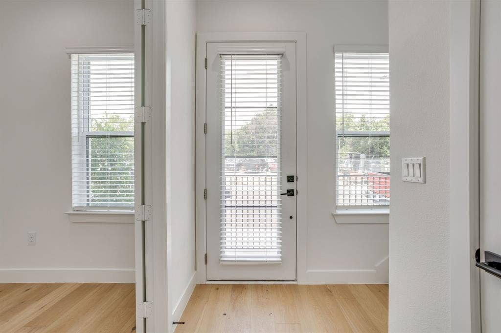 123 Thornton Street, Arlington, TX 76013 Interior space featuring wood-finish flooring, white walls, and a glass-paneled door with integrated blinds