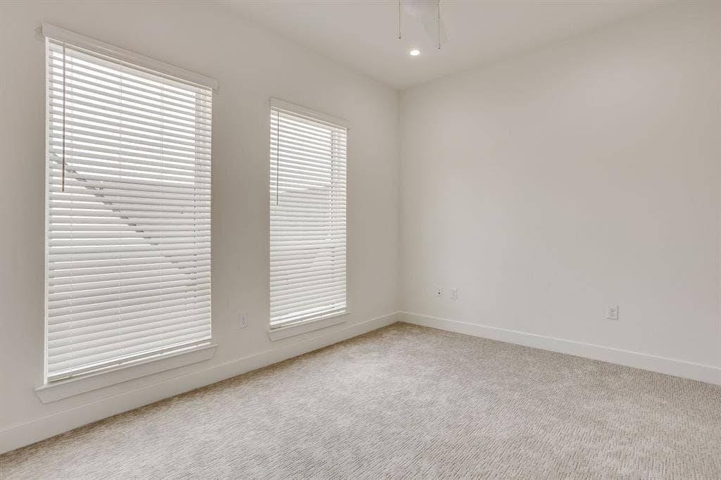 123 Thornton Street, Arlington, TX 76013 Bright interior space featuring two windows with horizontal blinds, carpeted flooring, white walls, and a recessed ceiling light
