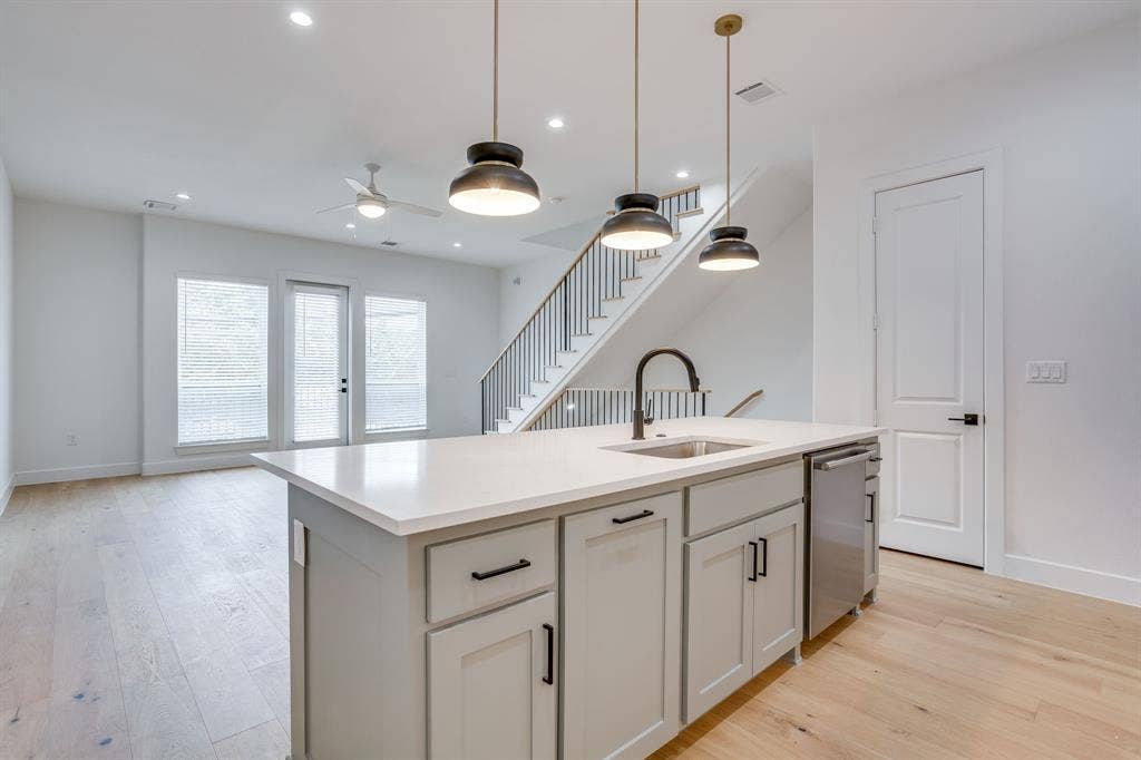 123 Thornton Street, Arlington, TX 76013 Kitchen island with a light-toned countertop, stainless steel sink, and gooseneck faucet