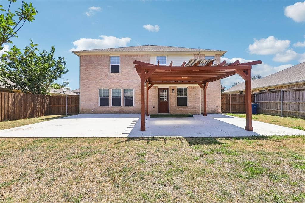 503 Angela Lane, Euless, TX 76039 Expansive concrete patio featuring a wood pergola structure, enclosed by privacy fencing
