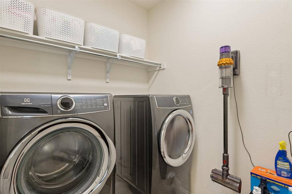 Dedicated laundry area featuring a white wall shelf, offering storage above the appliances