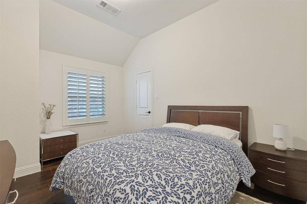 Interior room featuring a vaulted ceiling and wood-finish flooring