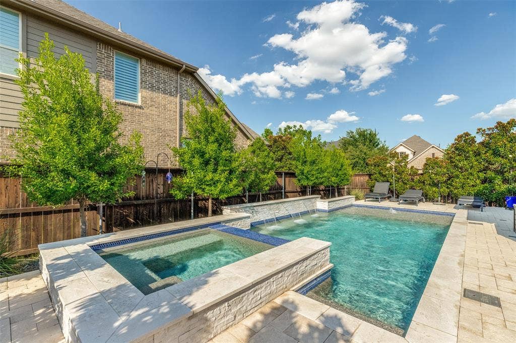 Outdoor pool and spa with stone coping and perimeter tile