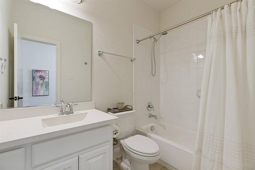 Bathroom featuring a white vanity with an integrated sink, polished chrome faucet, built-in mirror, and a tub/shower combination with white subway tile surround