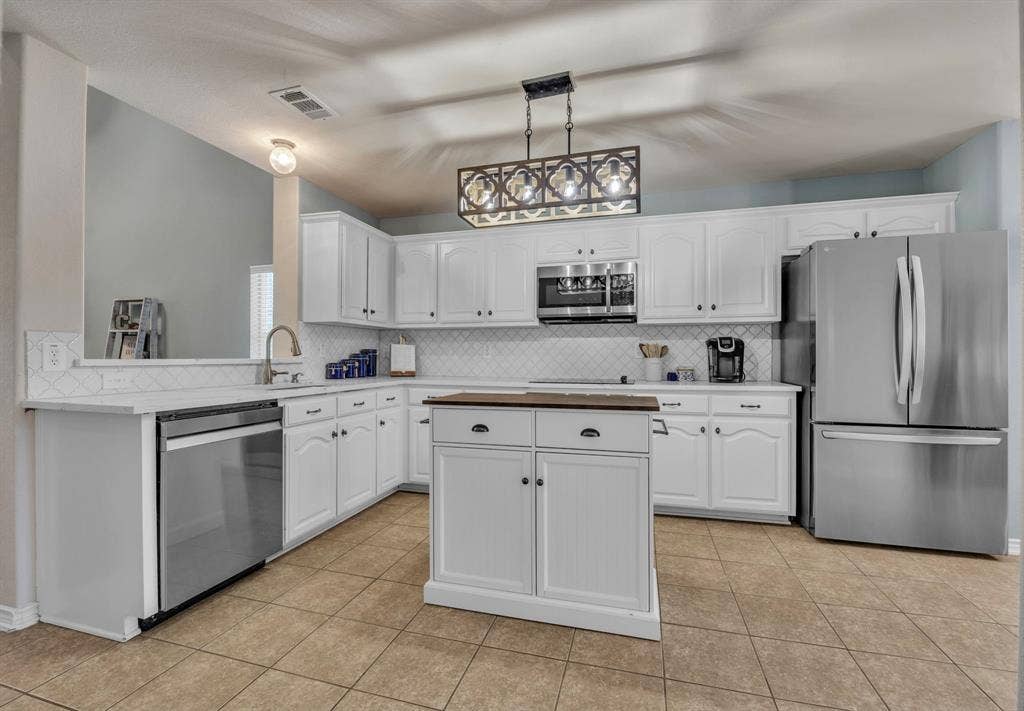 1201 Destiny Court, Wylie, TX 75098 Renovated kitchen with quartz countertops, stainless steel appliances, backsplash, and new lighting.