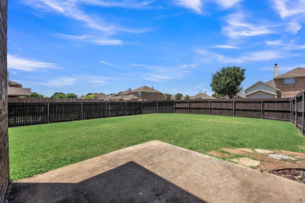 1201 Destiny Court, Wylie, TX 75098 Expansive backyard featuring a manicured lawn, full perimeter fencing, and a concrete patio