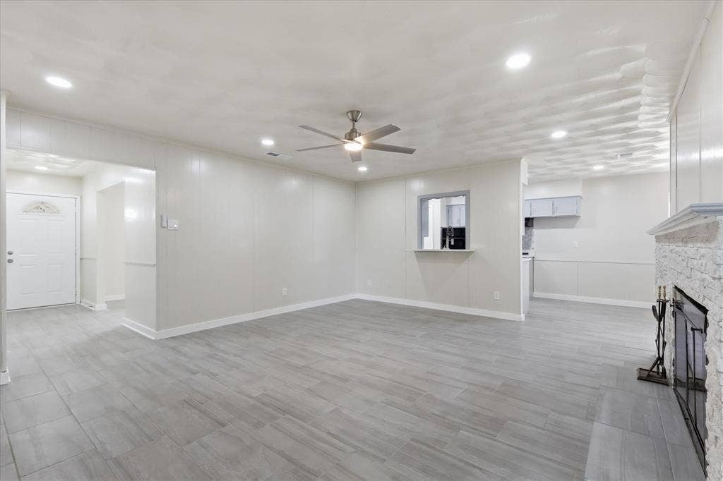 3301 Hillsdale Lane, Garland, TX 75042 Spacious living area featuring light gray wood-finish flooring, recessed lighting, and a contemporary ceiling fan