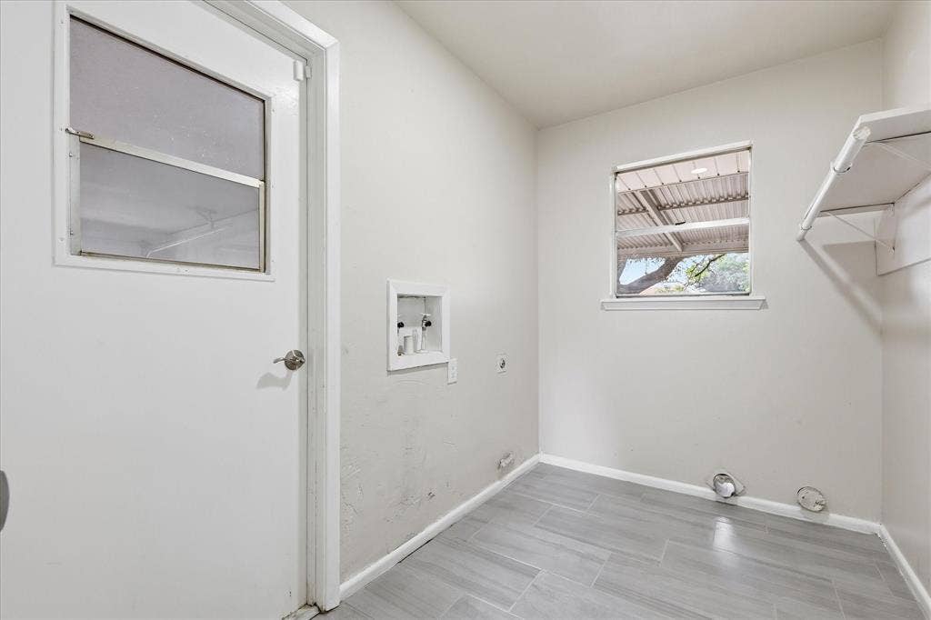 3301 Hillsdale Lane, Garland, TX 75042 Utility room with wood-finish tile flooring, a window offering natural light, and built-in shelving