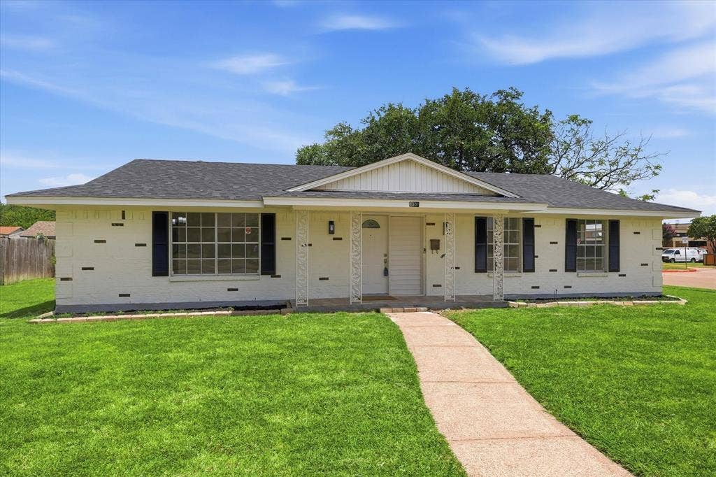 3301 Hillsdale Lane, Garland, TX 75042 Single-story residence featuring a white brick exterior with dark accent bricks, a dark shingle roof, and a front gabled entry