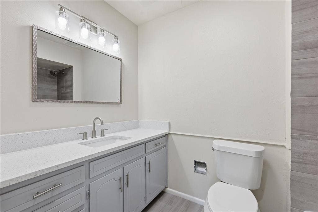 3301 Hillsdale Lane, Garland, TX 75042 Bathroom vanity featuring a light quartz countertop, undermount sink, and brushed nickel fixtures