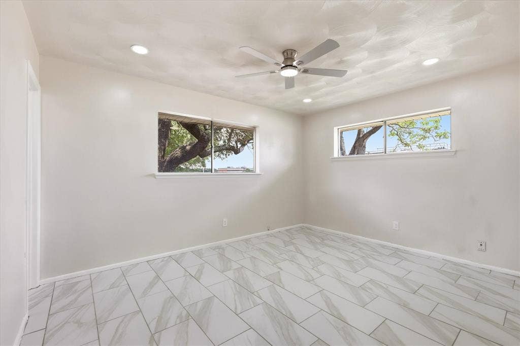 3301 Hillsdale Lane, Garland, TX 75042 Recessed lighting illuminates this room featuring light-colored walls and large format tile flooring