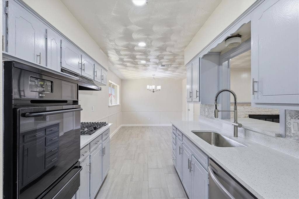 3301 Hillsdale Lane, Garland, TX 75042 Galley kitchen featuring light-toned cabinetry, light-toned countertops, tile flooring, a built-in oven, and a gas cooktop
