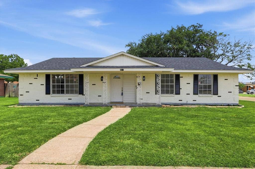 3301 Hillsdale Lane, Garland, TX 75042 Single-story residence featuring a white brick facade with contrasting dark accents and a dark shingle roof