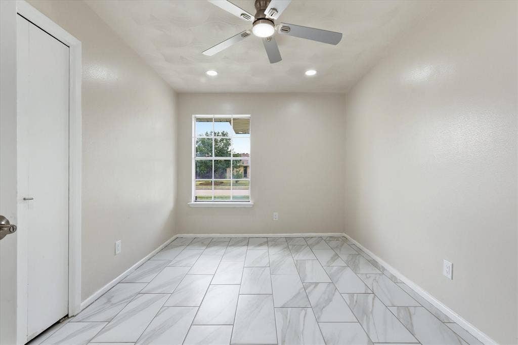 3301 Hillsdale Lane, Garland, TX 75042 Room featuring large format tile flooring, a window with exterior views, a ceiling fan with integrated lighting, and recessed ceiling lights
