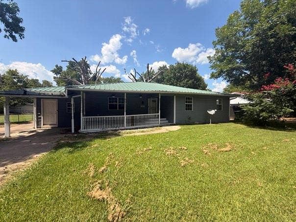209 Lone Star Road, Trinidad, TX 75163 Exterior featuring siding, a green metal roof, covered front porch with white railing, and a carport