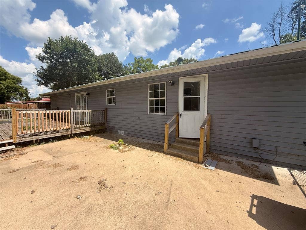 209 Lone Star Road, Trinidad, TX 75163 Exterior featuring gray siding, a white entry door with steps and handrails, and a wooden deck with railing