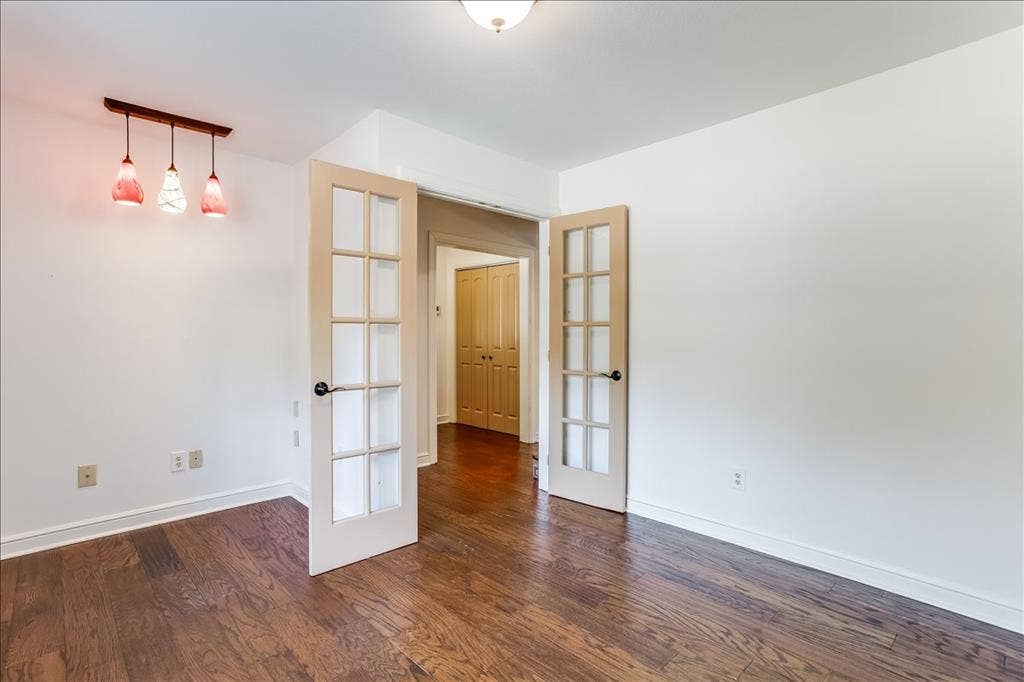 Room featuring wood-finish flooring, white baseboards, and neutral wall paint