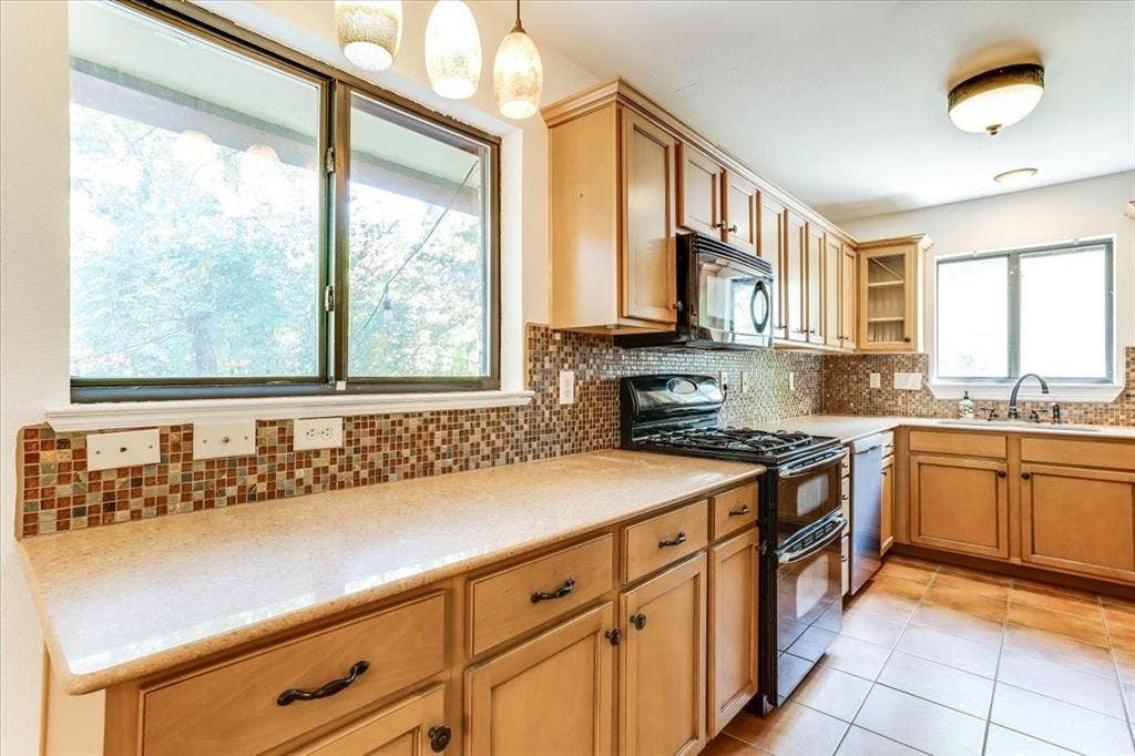 Kitchen featuring wood-finish cabinetry, mosaic tile backsplash, and light-toned countertops