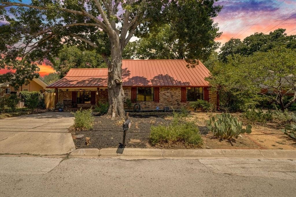 Stone-clad exterior with a red metal roof and front porch