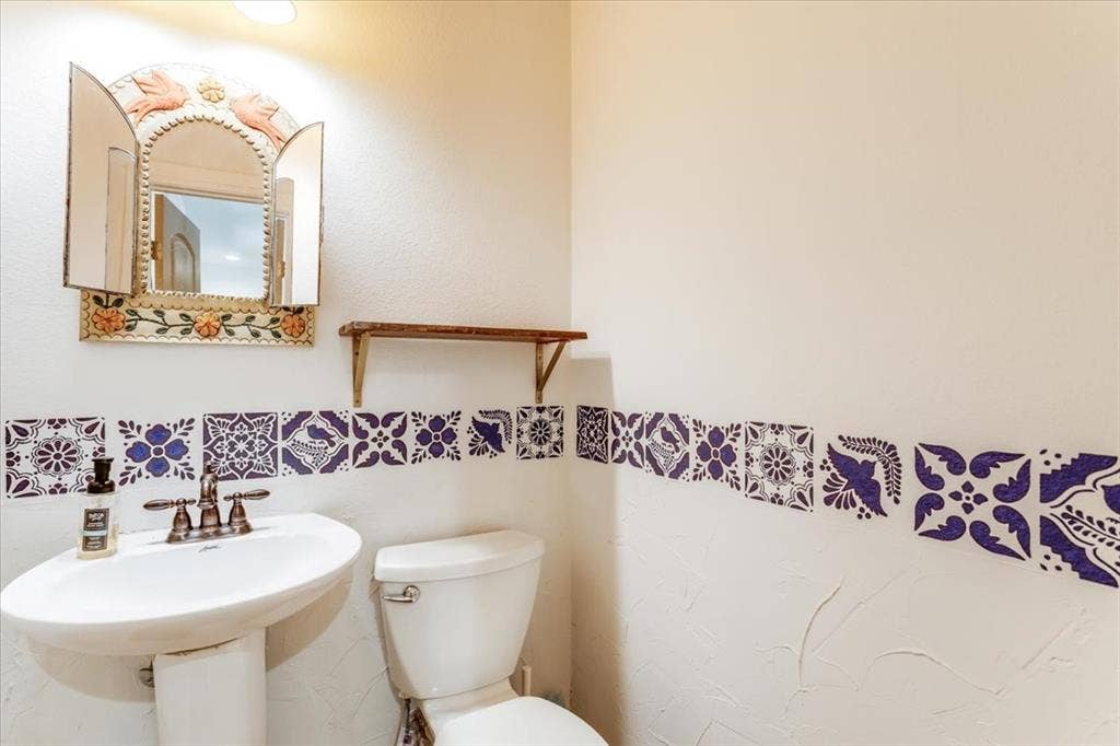 Pedestal sink with a two-handle faucet, accompanied by a white toilet