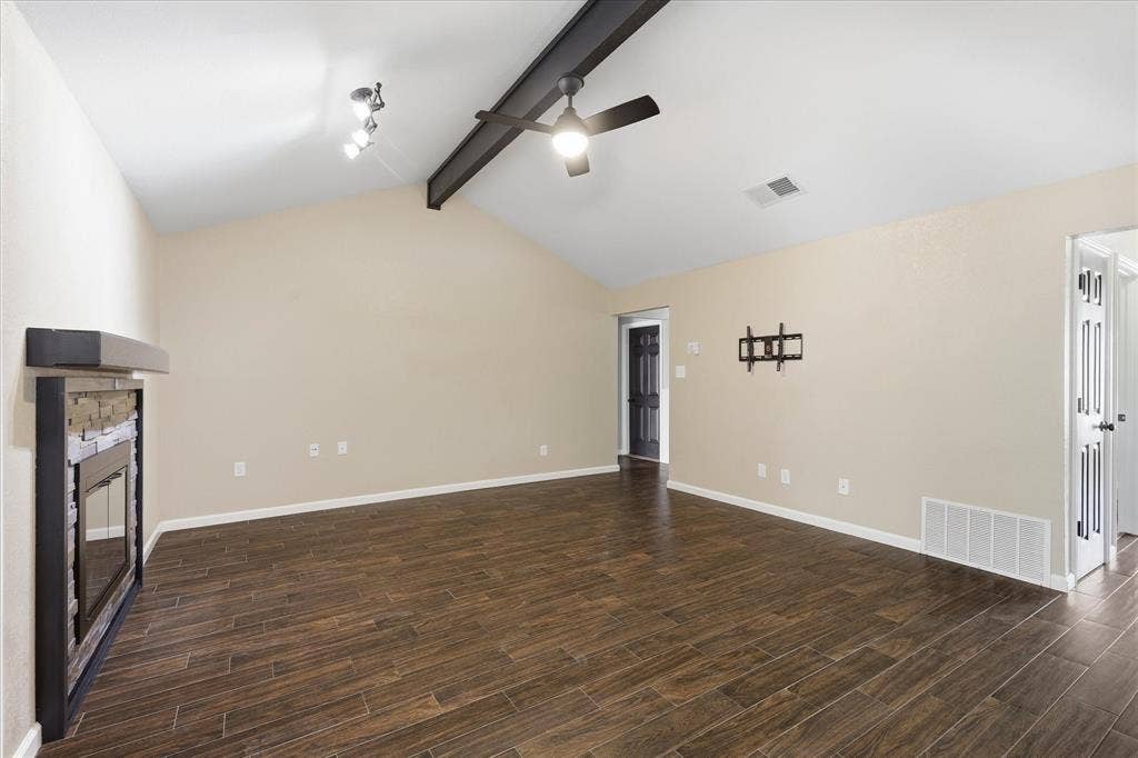 6572 Ridglea Drive, Watauga, TX 76148 Living area featuring wood-finish flooring, vaulted ceiling with exposed beam, and a ceiling fan