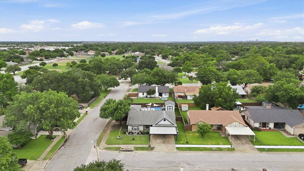 6572 Ridglea Drive, Watauga, TX 76148 Residential street lined with mature trees, showcasing a variety of single-story homes with established landscaping