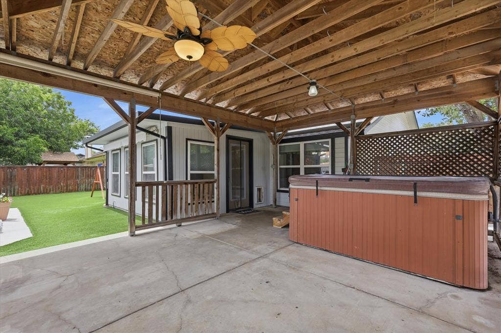 6572 Ridglea Drive, Watauga, TX 76148 Covered patio featuring a wood-frame structure, ceiling fan with leaf-shaped blades, and exposed wood rafters