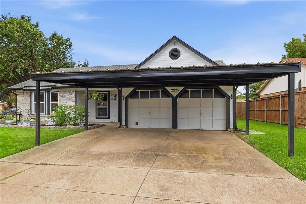 6572 Ridglea Drive, Watauga, TX 76148 Exterior featuring a black metal carport, a driveway, and a manicured lawn