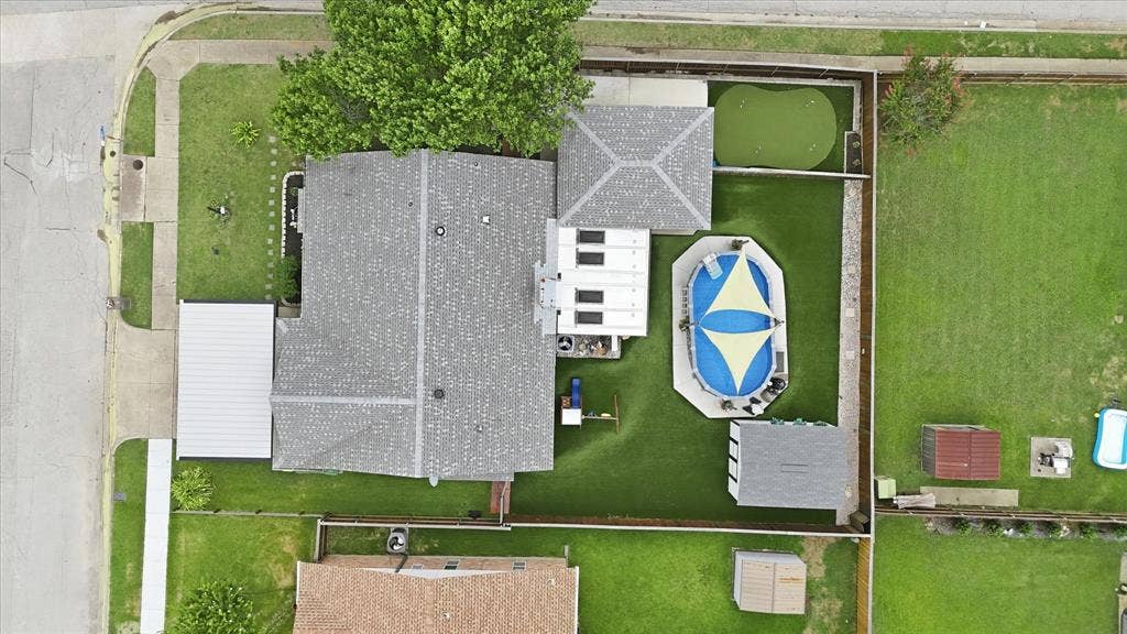 6572 Ridglea Drive, Watauga, TX 76148 Property featuring an above-ground pool, putting green, detached structure, and manicured lawn