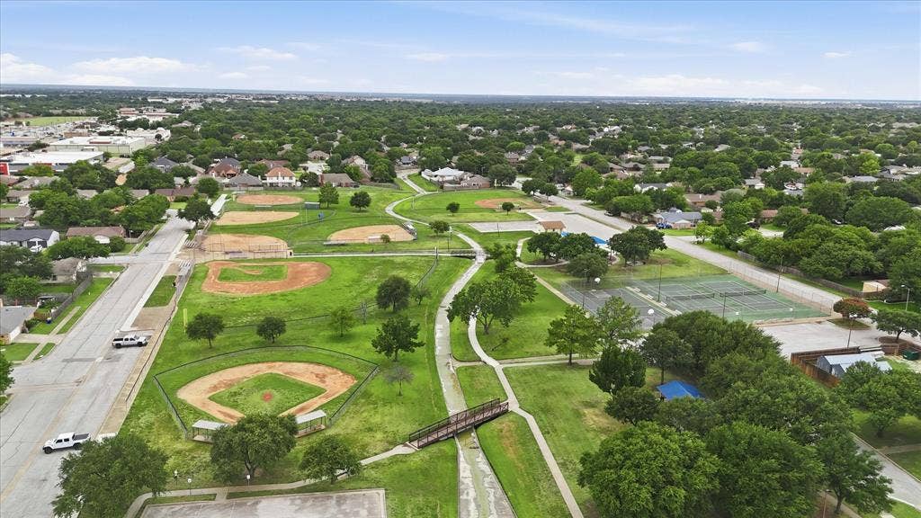 6572 Ridglea Drive, Watauga, TX 76148 Expansive park featuring multiple baseball diamonds, tennis courts, paved walking paths, and mature trees