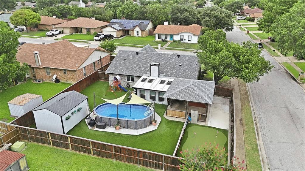 6572 Ridglea Drive, Watauga, TX 76148 Expansive backyard featuring an above-ground pool, covered patio, artificial turf putting green, and two storage sheds
