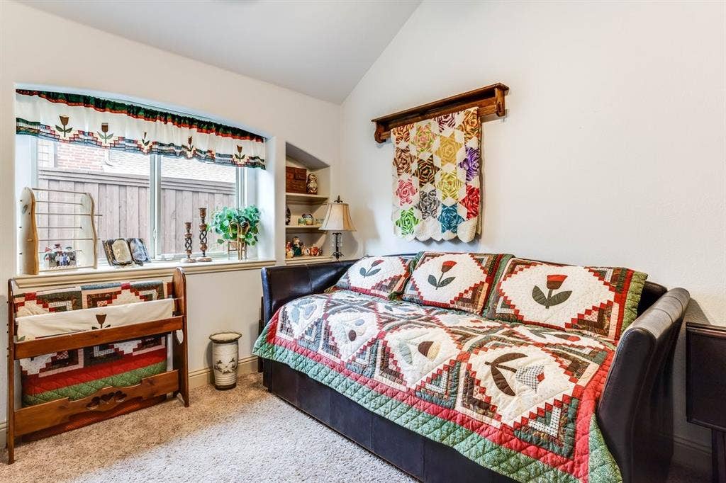 114 Lyndhurst Drive, Wylie, TX 75098 Carpeted room featuring an arched window, a built-in shelving alcove, and a vaulted ceiling