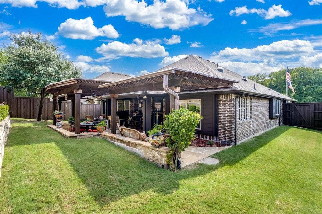 114 Lyndhurst Drive, Wylie, TX 75098 Expansive backyard featuring a stone patio, twin pergolas, and a manicured lawn
