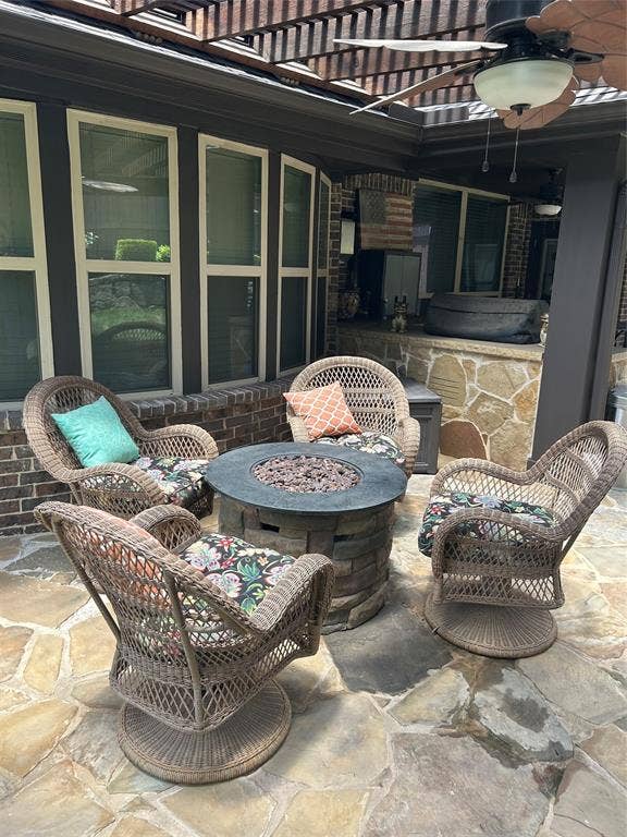 114 Lyndhurst Drive, Wylie, TX 75098 Flagstone patio with a built-in fire pit, covered by a wooden pergola, and equipped with a ceiling fan