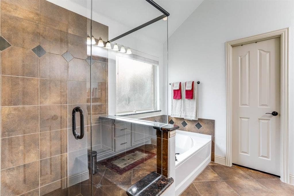 114 Lyndhurst Drive, Wylie, TX 75098 Glass-enclosed shower with brown and dark accent tiling